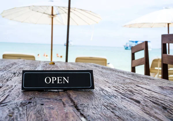 Відкритий банер на столі ресторану, пляжний фон — стокове фото