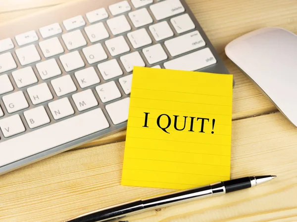 QUIT em nota pegajosa em uma mesa — Fotografia de Stock