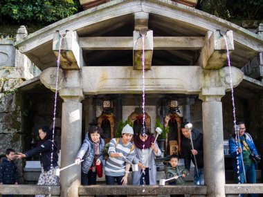 Ziyaretçi Otowa şelale Kiyomizu-dera Tapınağı'nda uzun direkleri içecek bağlı bardak kullanın