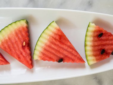 Karpuz dilimleri düz plaka üzerinde üstten görünüm yatıyordu