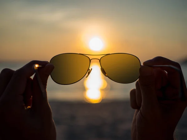 Силуетні окуляри з руками тримаються, з заходом сонця на пляжі — стокове фото