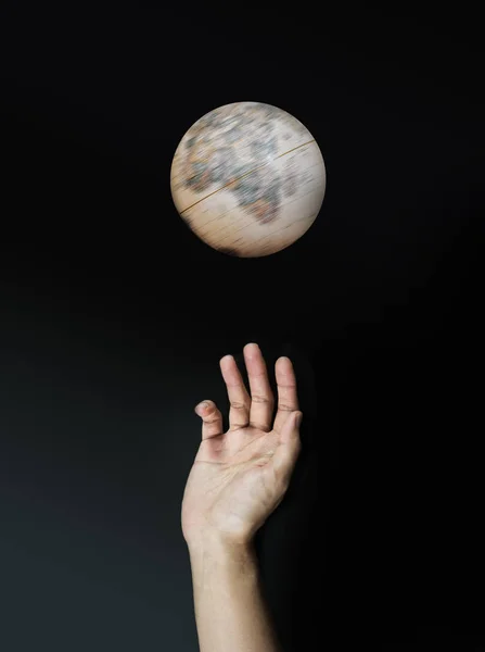 Duisternis verricht draaiende globe en hand die reikt, wereld milieu probleem concept — Stockfoto