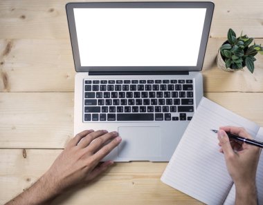 Not Defteri ile ahşap masa üzerinde çalışıyor