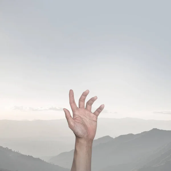 Hand raising up in the mountain