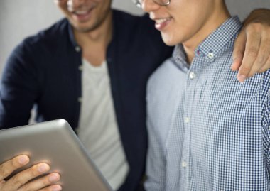 Erkekler kullanarak tablet sarılma ve mutlu görünüyordu talk