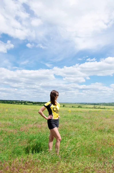 Chica está de pie en el campo verde —  Fotos de Stock