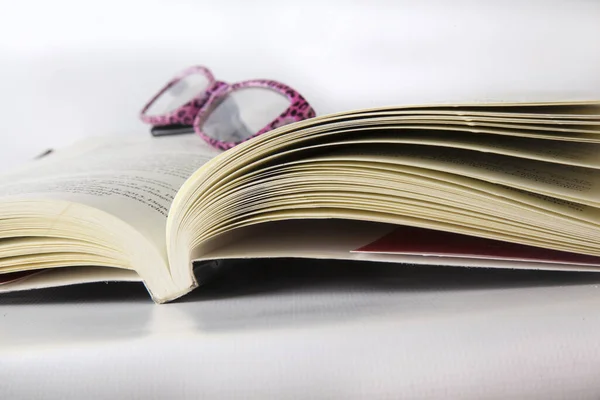 Libro abierto con lentes arriba