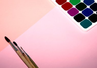 suluboya fırça üzerinde pembe bir arka plan, üstten görünüm ile boyar