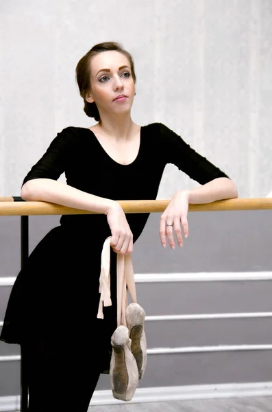 Graziosa ballerina in piedi vicino alla sbarra del balletto in una bella — Foto Stock