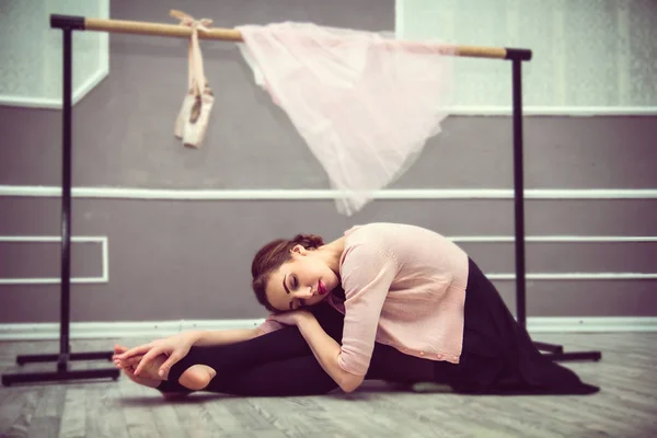 Giovane bella ballerina graziosa riposo in classe di balletto sitti Foto Stock