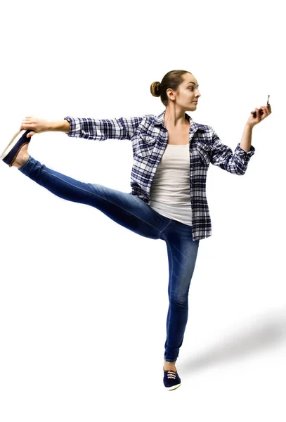 Young woman doing yoga in casual clothes, looking in the mirror. — Stock Photo, Image