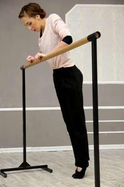 Pretty young graceful ballet dancer warms up in ballet class — Stock Photo, Image