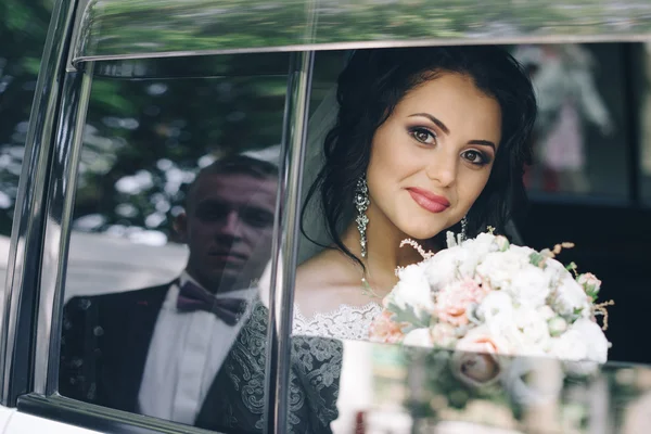 A boldog menyasszony és a vőlegény az autóban portréja — Stock Fotó