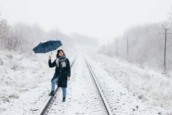 Uma menina bonita segura guarda-chuva nas mãos da temporada de inverno — Fotografia de Stock