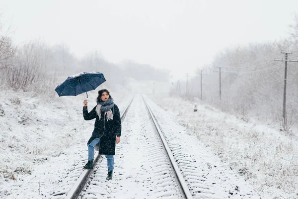 Uma menina bonita segura guarda-chuva nas mãos da temporada de inverno — Fotografia de Stock