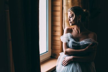 Pencerenin önünde duran kadın