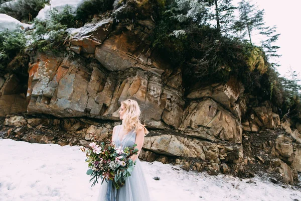 The young pretty girl waits for her lover in the middle of the mountains covered with snow — Stock Photo, Image