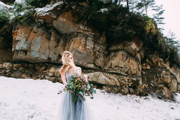 The young pretty girl waits for her lover in the middle of the mountains covered with snow — Stock Photo, Image