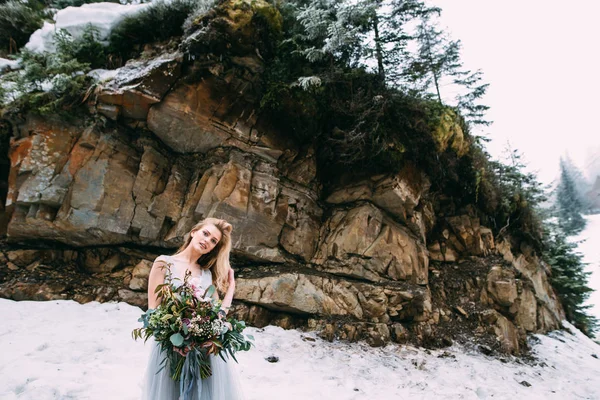 The young pretty girl waits for her lover in the middle of the mountains covered with snow — Stock Photo, Image