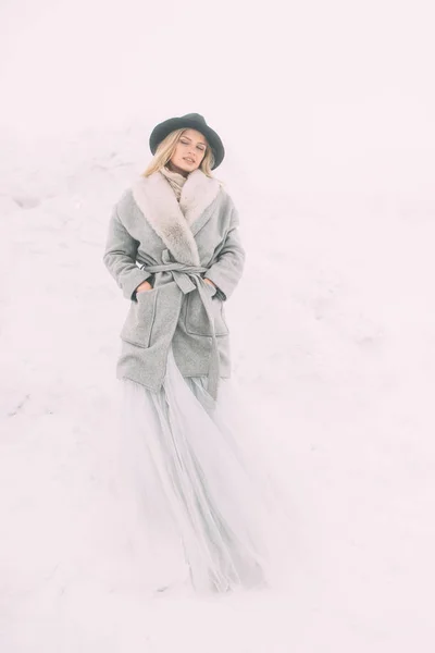 Schönes Winterporträt einer jungen Frau in der verschneiten Winterlandschaft. — Stockfoto