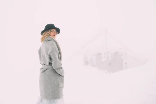 Schönes Winterporträt einer jungen Frau in der verschneiten Winterlandschaft. — Stockfoto