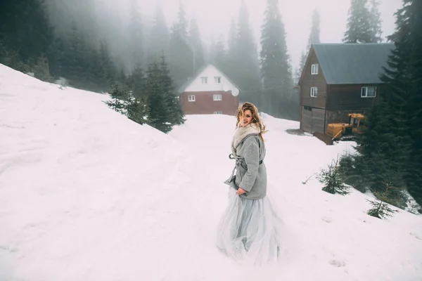 De Jong mooi meisje op haar minnaar in het midden van de bergen wacht bedekt met sneeuw — Stockfoto