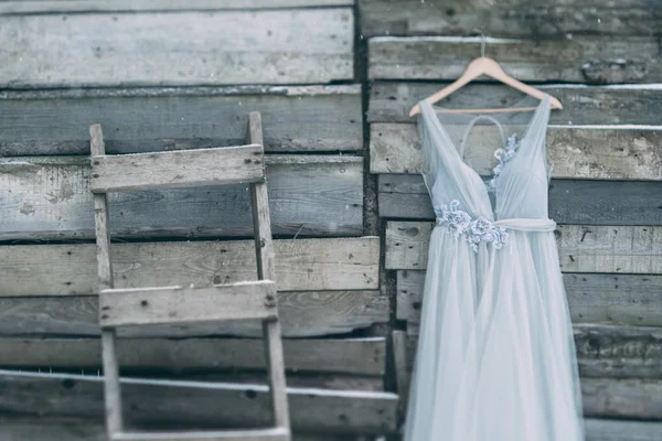 Krásné šaty šedé zavěšené na závěs na dřevěné pozadí — Stock fotografie