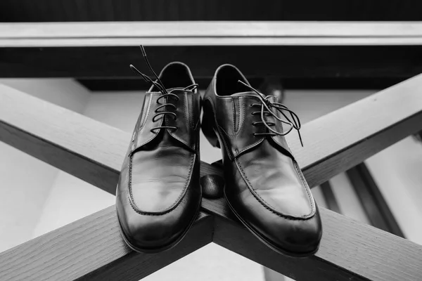 Obuwie meskie na piętrze z bliska czarny kolor. Drogie błyszczący polerowana skóra męskie buty stojący na tle neutralne podłogi drewniane — Zdjęcie stockowe