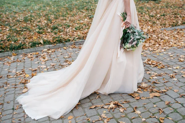 Belle mariée avec un bouquet de mariage dans leurs mains à l'extérieur dans un parc — Photo