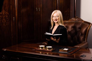 Çekici genç kadın güzel bir ofiste oturur