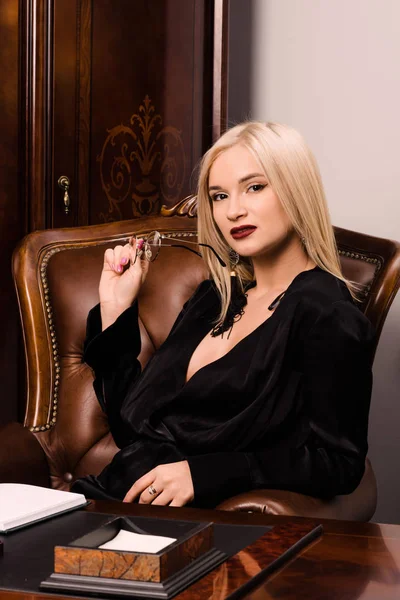Ελκυστική νεαρή γυναίκα που κάθεται σε ένα όμορφο γραφείο — Φωτογραφία Αρχείου