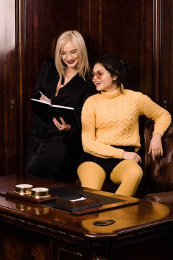 İki çekici genç kadın güzel bir ofiste oturur