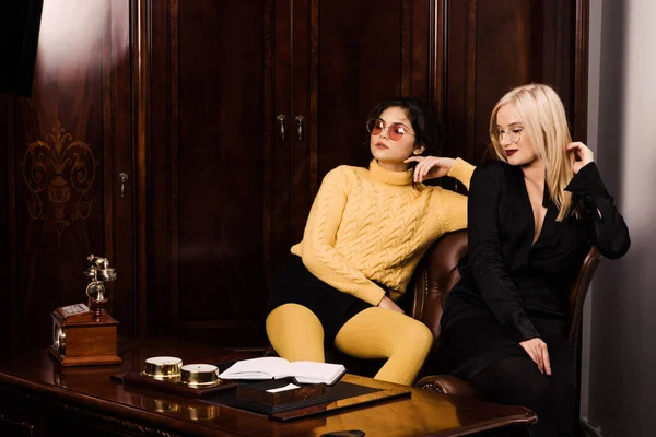 Two attractive young women sits in a beautiful office — Stock Photo, Image