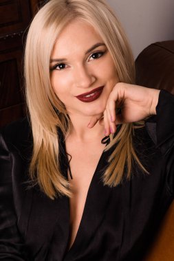 Çekici bir genç kız güzel deri koltukta oturur