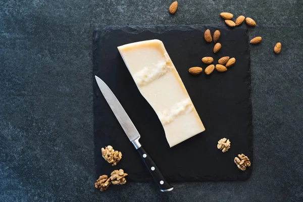 Gri taş zemin üzerine siyah bir tabakta iştah açıcı bir katı peynir