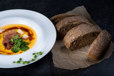 İştah açıcı bir balkabağı çorbası beyaz bir tabak bir restoranda servis edilir