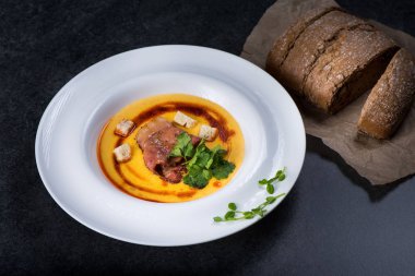 İştah açıcı bir balkabağı çorbası beyaz bir tabak bir restoranda servis edilir