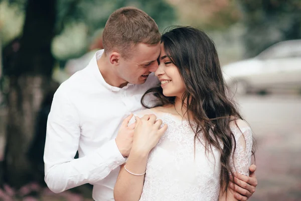 Feliz joven pareja enamorada disfruta del día de primavera, hombre amoroso sosteniendo en las manos a su mujer sin preocupaciones caminando por el parque — Foto de Stock