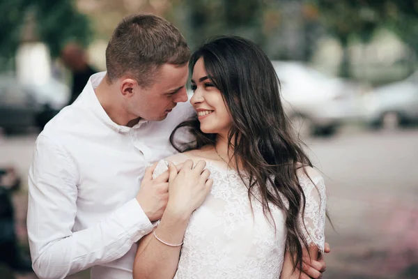 Feliz joven pareja enamorada disfruta del día de primavera, hombre amoroso sosteniendo en las manos a su mujer sin preocupaciones caminando por el parque — Foto de Stock