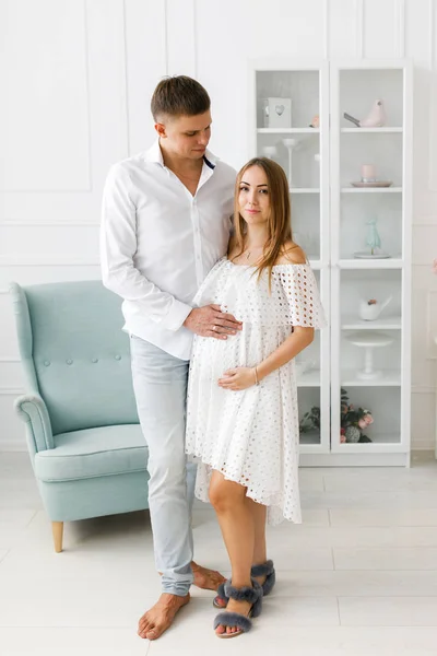 Young pregnant woman with husband in room. Woman waiting for a newborn baby. — Stock Photo, Image