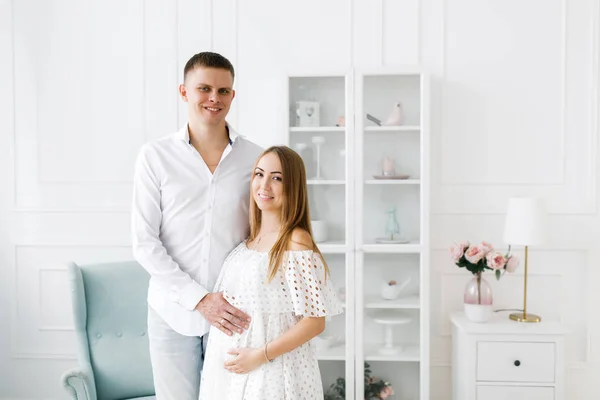 Young pregnant woman with husband in room. Woman waiting for a newborn baby. — Stock Photo, Image