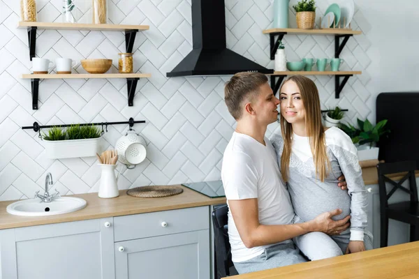 Junges Paar - Mann und Frau erwarten ein Baby, verbringen Zeit in der Küche. in Erwartung der Geburt eines Babys — Stockfoto