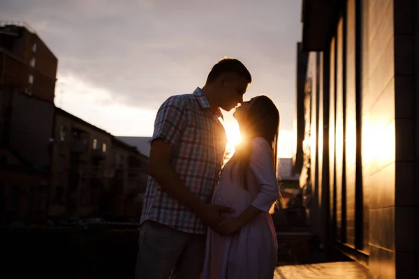 Young couple - man and woman expecting a baby, spend time together on the city street at sunset. — ストック写真