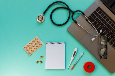 Doctor desk table with stethoscope and laptop computer. Top view with copy space, flat lay.