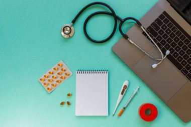 Doctor desk table with stethoscope and laptop computer. Top view with copy space, flat lay.