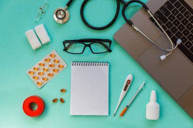 Doctor desk table with stethoscope and laptop computer. Top view with copy space, flat lay.