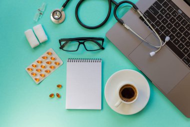 Doctor desk table with stethoscope and laptop computer. Top view with copy space, flat lay.