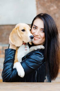 Güzel esmer kız, sevgili köpeğinin kollarına giriyor. Kız dışarıda köpekle vakit geçiriyor, av köpeği yetiştiriyor.
