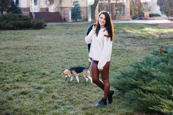 Jolie fille brune passe activement du temps avec son chien mignon préféré. Fille trains sur le chien de rue, beagle race — Photo