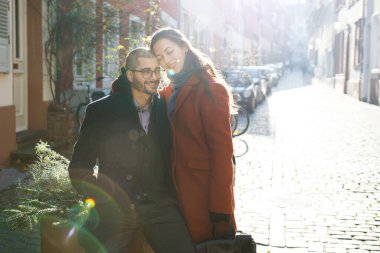 Güneşli bir kış gününde romantik bir yürüyüş yapan mutlu genç çift.
